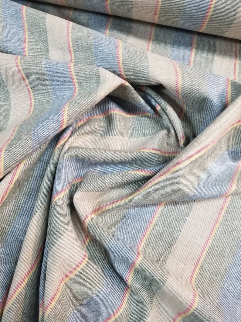 Pu&ograve; includere: Tessuto a righe in tonalit&agrave; di blu, verde, rosa e beige. Il tessuto ha una trama tessuta ed &egrave; piegato in modo da mostrare le righe.