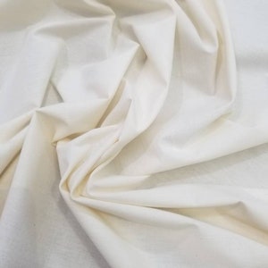 Puede incluir: Primer plano de una tela de algod&oacute;n blanca, mostrando su textura y ca&iacute;da.