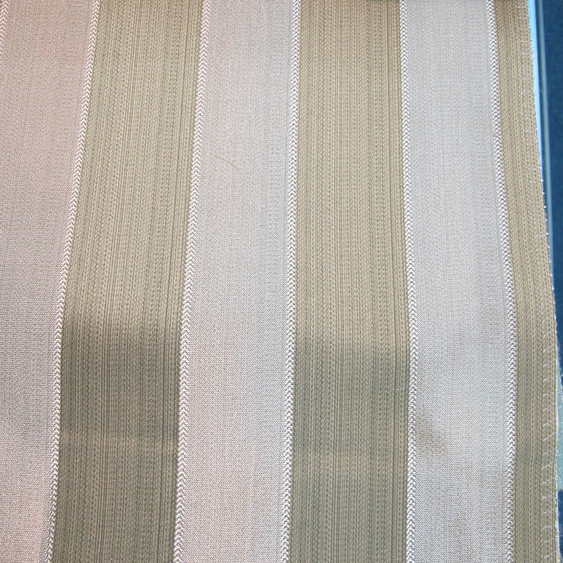 May include: A close-up of a fabric with alternating stripes of beige and white. The fabric has a subtle texture and a woven appearance.
