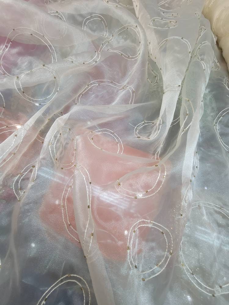 Sheer drapery fabric 60 inches wide striped design.  Off white  base embroidered with beads usable for interior designing.