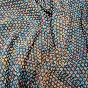 May include: Black fabric with a repeating pattern of small, colorful circles. The circles are arranged in diagonal rows and have a slightly raised texture.