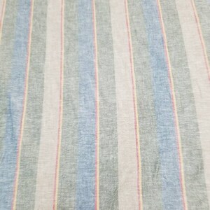 Pu&ograve; includere: Tessuto a righe con bande alternate di azzurro, grigio, rosa e giallo.