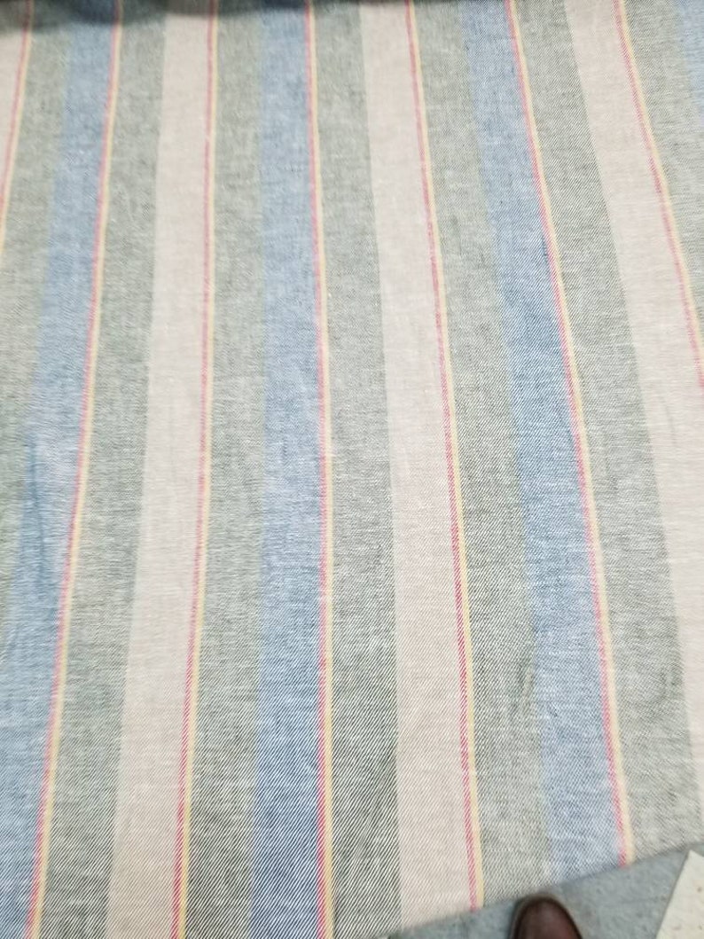 Pu&ograve; includere: Tessuto a righe con bande alternate di azzurro, grigio, rosa e giallo.