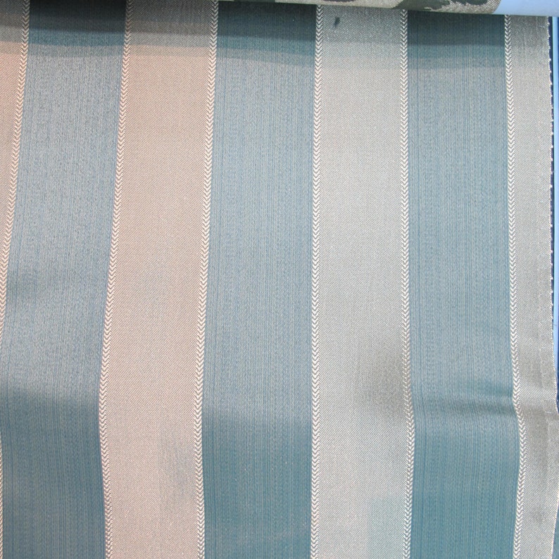 May include: A close-up of a fabric with alternating stripes of light blue and beige. The stripes have a subtle herringbone pattern.