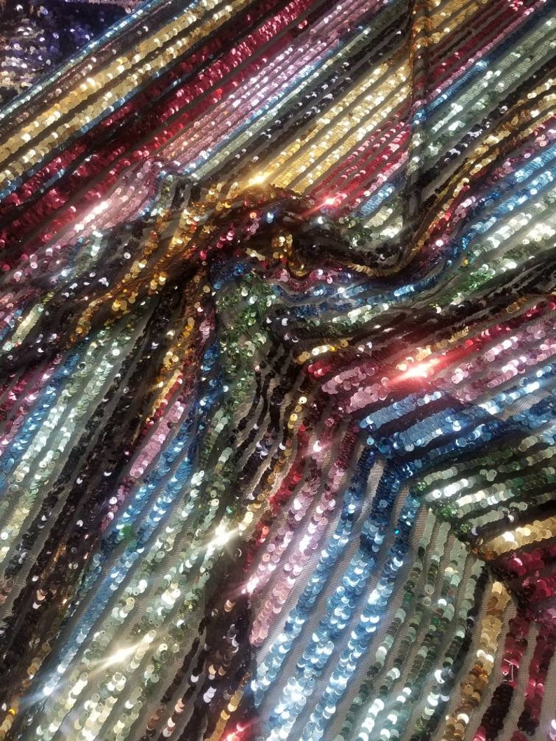54 wide. Multicolored striped sequences fabric usable for apparel accessories and interior designs