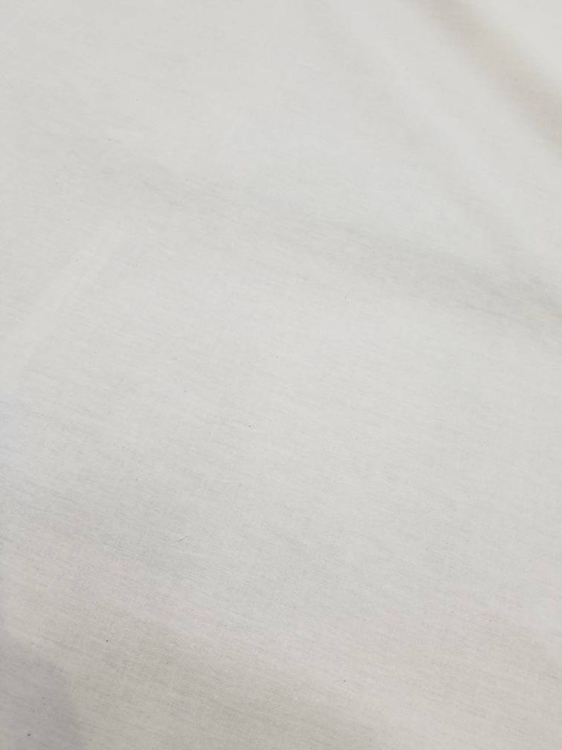 Puede incluir: Una superficie de tela blanca lisa con una textura sutil.