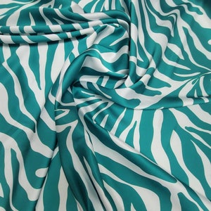 May include: Teal and white zebra print fabric with a silky texture.