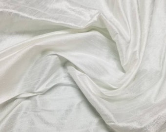 May include: White silk fabric with a smooth, lustrous texture. The fabric is draped and folded, creating soft folds and wrinkles.