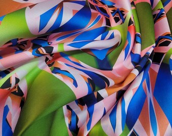 Desenhos abstratos multicoloridos impressos digitalmente em tecido Mikado/sarja premium de 59/60". Base verde com estampas multicoloridas.