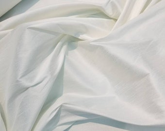 Tela shantung/dupioni color blanco roto. 137 cm de ancho. Su exclusiva combinación de shantung le da suavidad y estructura al vestido.