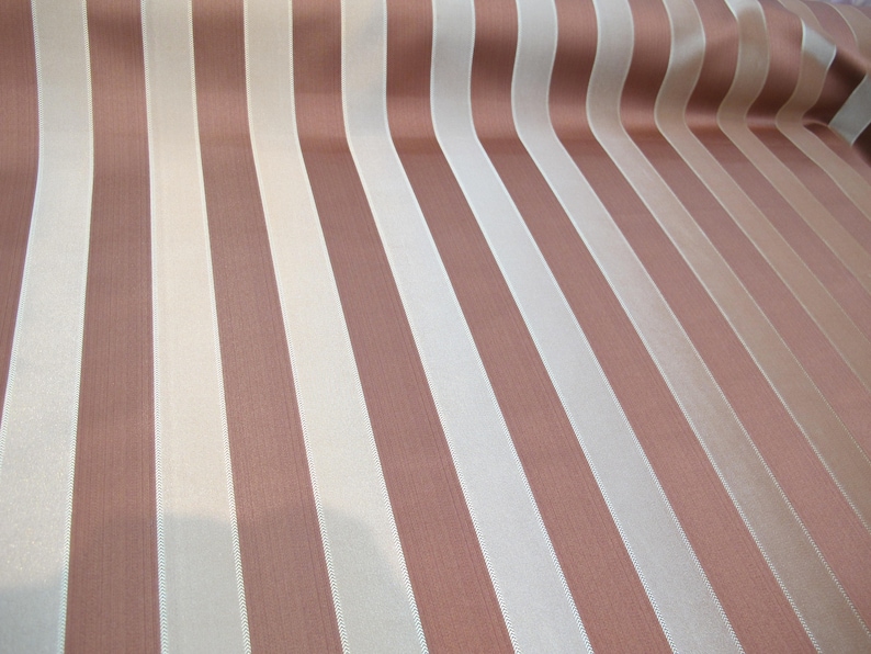 May include: A fabric with alternating stripes of brown and white. The fabric has a subtle sheen and a smooth texture.
