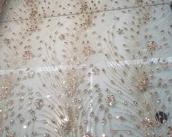 May include: Gold glitter fabric with a delicate, intricate pattern of small, round sequins. The fabric has a sheer, mesh-like texture.