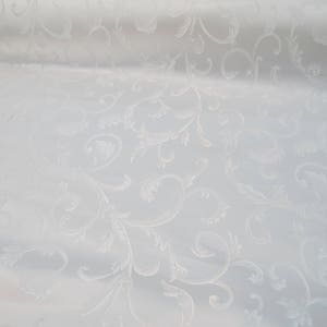 May include: White fabric with a subtle embossed pattern of swirling leaves and vines.