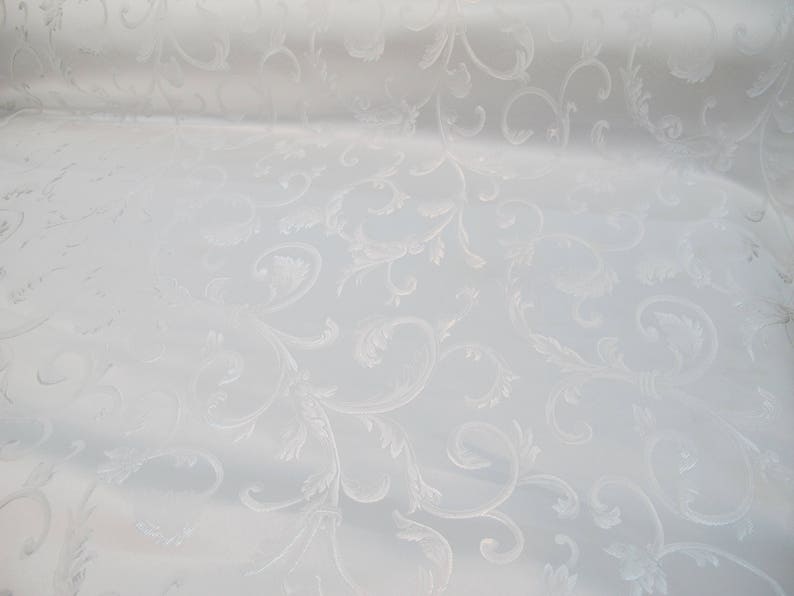 May include: White fabric with a subtle embossed pattern of swirling leaves and vines.