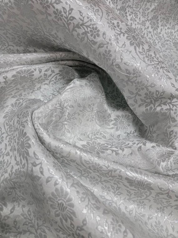 Handcrafted beautiful  silver color  brocade with mettallic thread    soft  fabric usable for apparel,accessories, and interior designs.