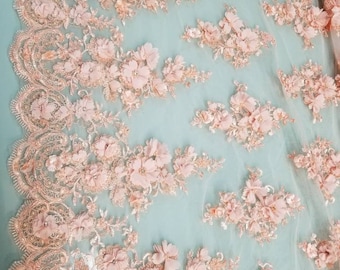 May include: Peach coloured floral lace fabric with 3D flowers. The lace has a delicate, intricate design with a light, airy feel.