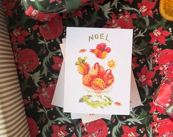 May include: A white Christmas card with a hand-painted illustration of a bowl of red and orange fruit with the word "NOEL" written in gold lettering.