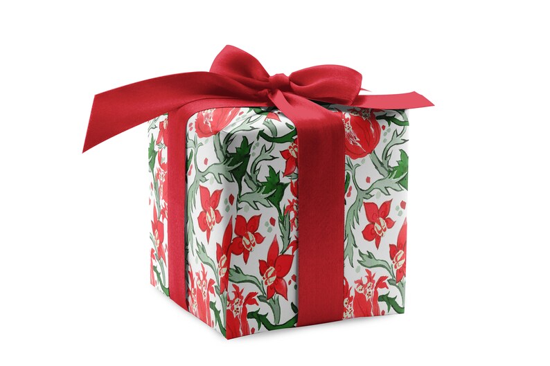 May include: A white gift box with a red ribbon and bow. The box is wrapped in floral patterned paper with red flowers and green leaves.