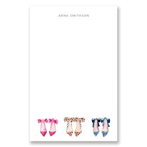May include: A set of three pairs of high-heeled shoes with bows. The shoes are pink with black polka dots, beige with black polka dots, and blue with white gingham.