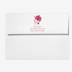 May include: White envelope with a pink floral design and the text "Kate Smith, 1234 Cherry Tree Lane, Cherry Tree, CA 98111"
