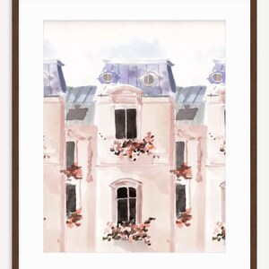 May include: Watercolor painting of a Parisian building facade. The artwork features a repeating pattern of light pink buildings with blue roofs, black windows, and flower boxes. The image is framed in a dark brown wooden frame.