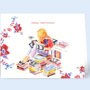 May include: A watercolor illustration of a woman sitting on a stack of books, reading a book. The woman has blonde hair and is wearing a red sweater and blue jeans. The background is white with a floral pattern.