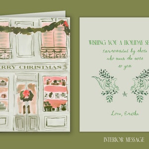 May include: A watercolor illustration of a storefront with a sign that reads "Merry Christmas". The storefront has two windows with pink and white displays and a door with a red wreath. The illustration is on a white background.