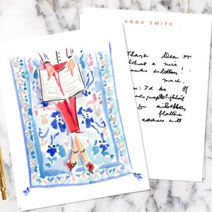 May include: A watercolor illustration of a person reading a book while lying on a blue and white patterned rug. The text on the notecard reads "These lea what a nice thanks lollipops! I'd be so praplelight sabella, flattere readers will"