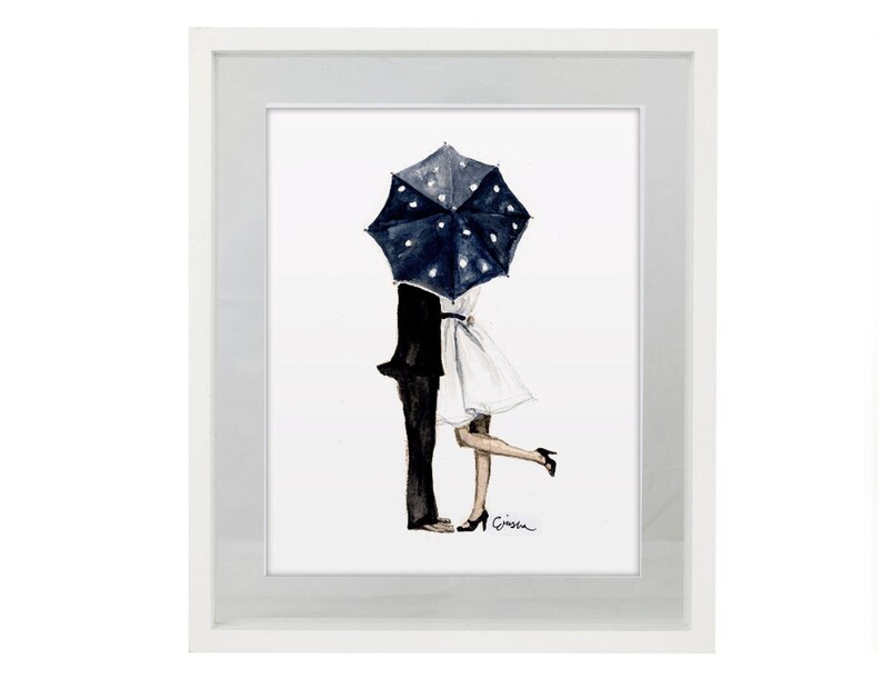May include: Watercolour art print showing a couple kissing beneath a navy blue umbrella with white polka dots. The artwork depicts a man in a black suit and a woman in a white dress, framed in a white border.