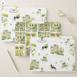 May include: Set of three file folders with a watercolor design of a Parisian garden scene. The design features a fountain, benches, and people walking through the garden. The folders are white with green accents.