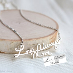May include: Silver necklace with a cursive script pendant that reads "Love Always Mom". A handwritten note with the same text is included.