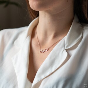 May include: A delicate gold necklace with a cursive name pendant that reads "Sophie".