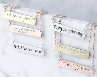 May include: Five silver bar necklaces with handwritten messages on each. The messages include "I lov-a you!" "You make me smile!" "Enjoy the journey." "I love you forever, Dad" and "Jake Kate" with a heart symbol.