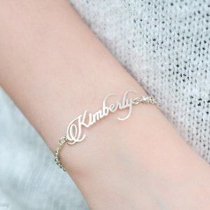 May include: A silver bracelet with the name "Kimberly" written in cursive.