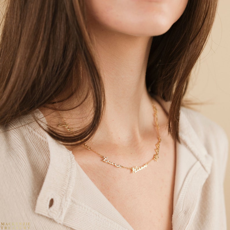 May include: A gold necklace with four names on it: "John", "Laura", "Alison", and "Olivia".
