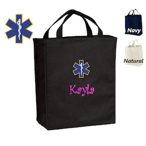 May include: Black canvas tote bag with a blue and gold medical symbol and the name Kayla embroidered in pink.