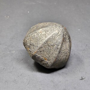 May include: A dark gray, rough, and textured, round, multi-faceted, iron object.