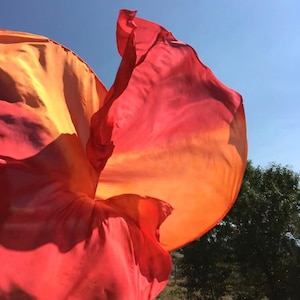 A pair of XL silk spin flags in orange and red.