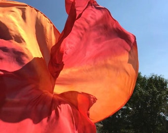 A pair of XL silk spin flags in orange and red.