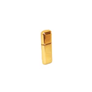 Peut inclure: Un briquet rectangulaire en métal doré avec une finition polie et réfléchissante. L'objet présente un capuchon supérieur arrondi et un corps droit et vertical. La surface est lisse et uniforme, reflétant la lumière sur tout son extérieur métallique.