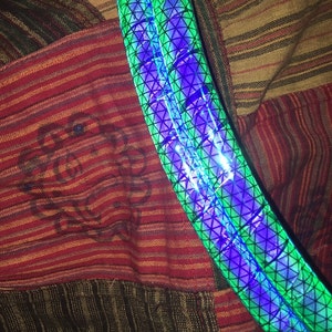 May include: A green and purple reflective strip with a geometric pattern.