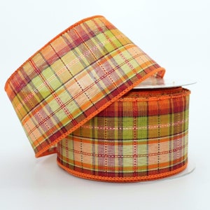 May include: Two spools of orange, green, and beige plaid ribbon with orange edges.
