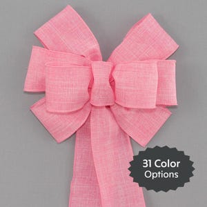 May include: A large pink bow made from a textured fabric. The bow has a long tail and is tied in a classic style. 31 Color Options.