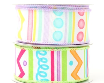 May include: Two rolls of colourful patterned ribbon. The top roll has a white background with purple, pink, yellow, and green stripes and blue and pink polka dots. The bottom roll has a white background with green, pink, purple, and orange stripes and a blue swirl pattern and orange chevron pattern.