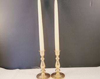 Può includere: Due portacandele in metallo dorato con candele bianche. I portacandele hanno un design classico con una base rotonda e uno stelo alto e sottile.