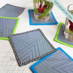 Op de afbeelding: Vier gequilte stoffen onderzetters met verschillende gekleurde randen. De onderzetters zijn grijs met een chevron-patroon en groene stiksels. De tekst "PDF pattern for sale" is zichtbaar in de rechterbovenhoek van de afbeelding. De tekst "staceyscraftdesigns.com" is zichtbaar in de rechterbenedenhoek van de afbeelding.