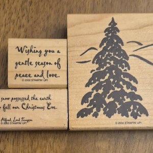 May include: Three wooden rubber stamps featuring a large evergreen tree, the text Wishing you a gentle season of peace and love, and the text The silent snow possessed the earth and calmly fell our Christmas Eve, all dated 2002 Stampin Up.