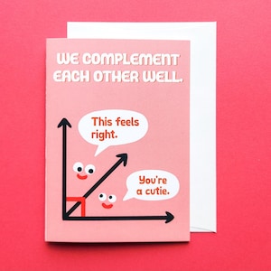 May include: A pink greeting card with the text "WE COMPLEMENT EACH OTHER WELL." features a cartoon graph with speech bubbles saying "This feels right." and "You're a cutie." A white envelope is behind the card.