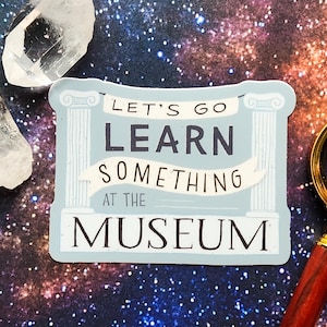 May include: A blue and white sticker with the text "Let's go learn something at the museum". The sticker is on a background of a galaxy with stars.