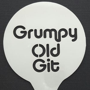 Könnte beinhalten: Weiße Kunststoffschablone mit dem Text "Grumpy Old Git" in schwarzen Buchstaben. Die Schablone ist tropfenförmig mit einem Loch am Boden.